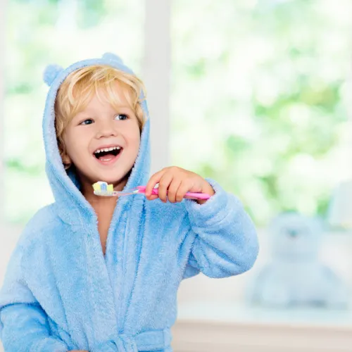 Child learning to brush teeth, pediatric dental care at Cusp Dental